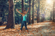 © Microgen - Woman Exercising With Elastic Band Outdoors in The Fall