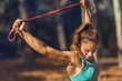 © Microgen - Woman Exercising With Elastic Band Outdoors in The Fall