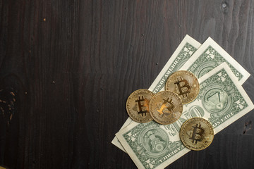 Bitcoin and dollar money on wooden desk