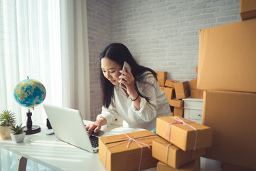 Start up small business entrepreneur SME or freelance asian woman typing computer with box, Young happy success woman with hands lift up , online marketing packaging box and delivery, SME concept