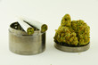 Marijuana buds and joints with herb grinder on white background