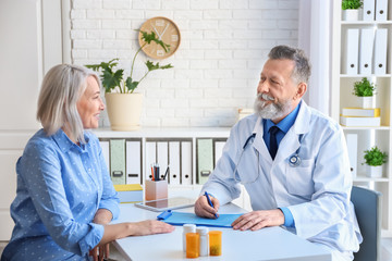 Canvas Print - Mature doctor consulting patient in clinic