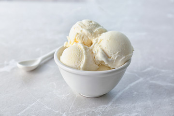 Wall Mural - bowl with tasty vanilla ice cream on light background