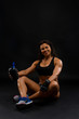 © ladie_c - Healthy Life. Bodybuilding Lifestyle Concept Image. Muscular Beautiful  Fitness Model Woman Athlete Smiling, Standing, Posing in Sportswear Top and Shorts and Drinks Water with Sports Nutrition.