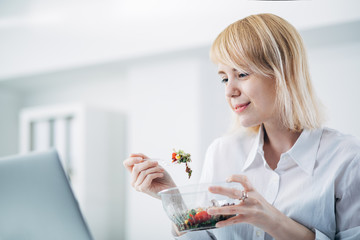 Young woman eating salad