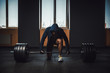 © Oleksandr - athletic man in jacket with a hood waiting and preparing before lifting heavy barbell. fitness, sport, training, gym and lifestyle concept. deadlift with barbell in mask. bent over the barbell