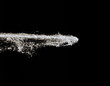 powerful jet of water with white foam isolated on black background. champagne splashes