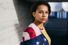 Portrait Of Young Woman Standing With American Flag