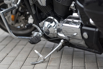 Motorcycle close-up. Detail of a beautiful powerful chrome motorcycle. The concept of freedom and travel. motorcycle is parked on street. large bicycle. Metallic shiny new internal combustion engine