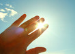 © far700 - The man's hand covers the sun. The man closes the palm of sunlight. Close-up. Background.