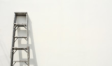 Aluminum Foldable Ladder And The Shadow At White Cement Wall