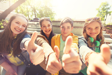 Poster - friendship, gesture and people concept - happy teenage friends or high school students showing thumbs up