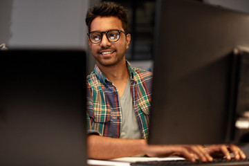 deadline, technology and people concept - close up of creative man in glasses working at night offic