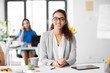 business, education and people concept - happy smiling african american woman in glasses at office