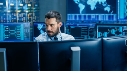 Leinwandbilder - In the System Control Center Operator Working Surrounded by Displays Showing Relevant Data. In the Background Data with Interactive Map.
