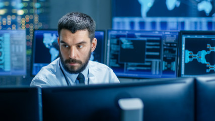 Leinwandbilder - In the Monitoring Room Technical Operator Attentively Monitors Stability of the System. He's Surrounded By Screens Showing Technical Data.