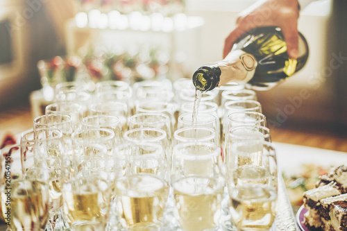 Cuadros en Lienzo waiter pouring champagne in stylish glasses at luxury wedding reception