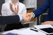 © rogerphoto - Business people shaking hands, finishing up a meeting. Audit, tax service or agreement concept