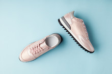 Pastel Pink Female Sneakers On Blue Background. Flat Lay, Top View Minimal Background.