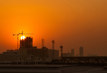 Tower cranes and building over sunset.