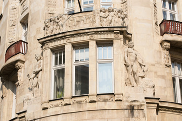 Element of an old building with a window and balconies, decorated with bas-reliefs and sculptures