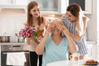 Young woman with daughter congratulating mature family member at home. Happy Mother's Day