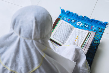 Wall Mural - Muslim woman reads Quran during ramadan time