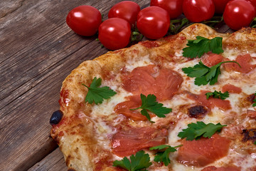 Homemade fresh delicious gourmet pizza whit salmon, garlic and fresh parsley,Tasty italian pizza isolated on wooden table,Close up with selective focus