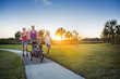 © Brocreative - Beautiful, fit young family walking and jogging together outdoors along a paved sidewalk in a park pushing a stroller at sunset