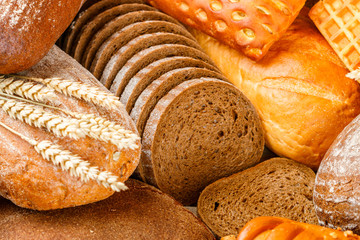 Wall Mural - Freshly baked rye and wheat bread on the table. Whole and sliced loaves