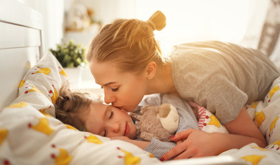 Poster - mother wakes her daughter in bed in  morning