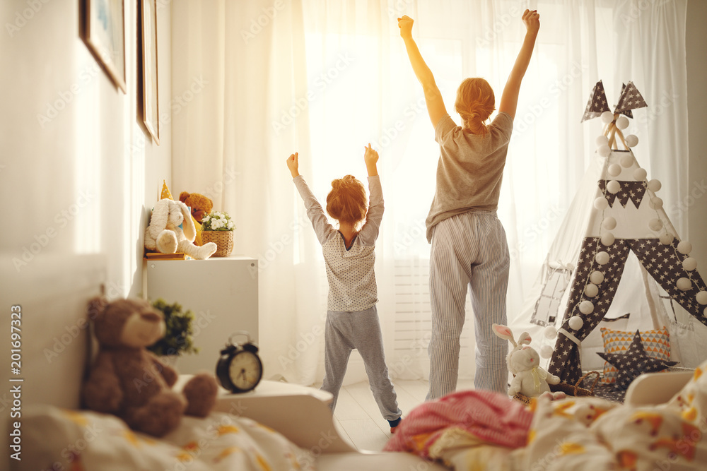 mother and child daughter stretch themselves after waking up in the morning
 - obrazy, fototapety, plakaty 