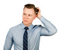 © vika33 - Young thinking businessman dressed in blue shirt and tie scratches his head, isolated on white background