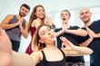 © yurakrasil - a happy group of people from man and woman practicing yoga in the studio and making selfies on the phone. groups of meditation and support in the yoga class. men and women have fun