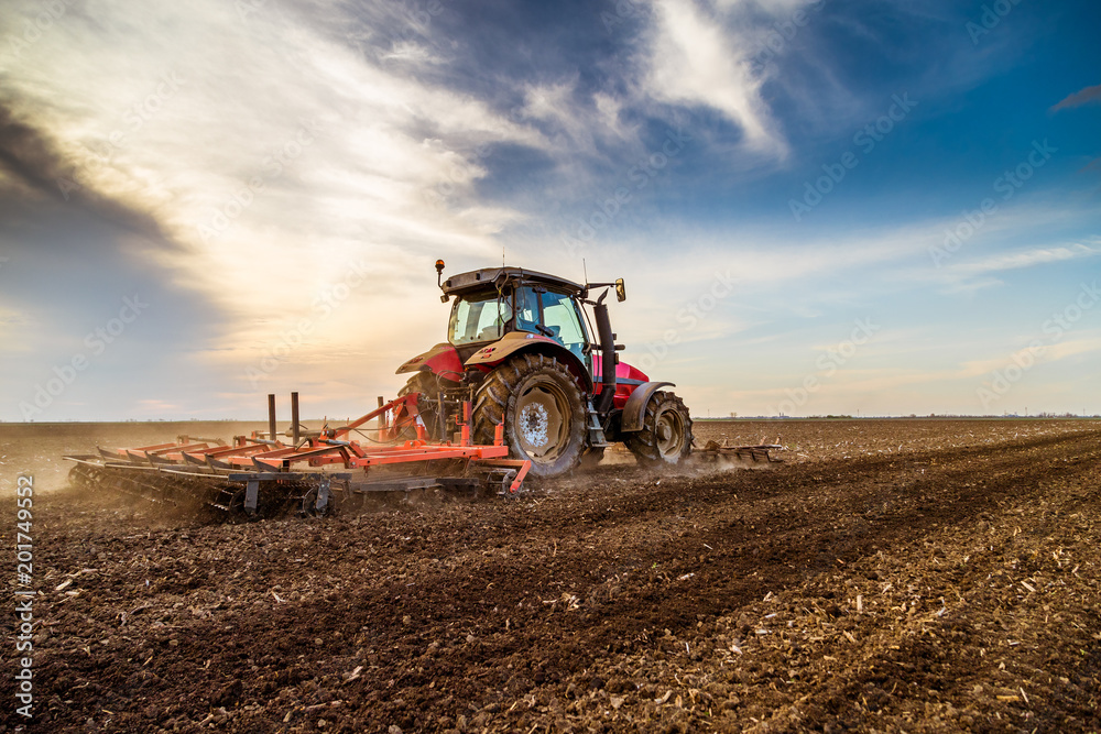 Tractor cultivating field at spring - obrazy, fototapety, plakaty 