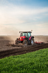 Tractor cultivating field at spring