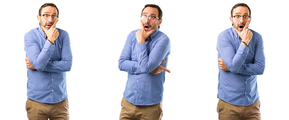 Canvas Print - Middle age handsome man scared in shock, expressing panic and fear over white background