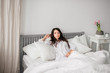 © natasidorova  - sexy young brunette woman wearing a white shirt on the bed at home. Girl's morning