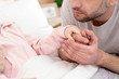 © Viacheslav Yakobchuk - My baby. Caring serious daddy holding his girls hand and watching her sleeping