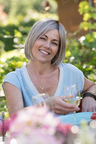 Portrait of a beautiful woman in her forties, sits at a table Poster