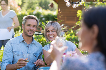 summer. Group of friends gathered around a table in the garden