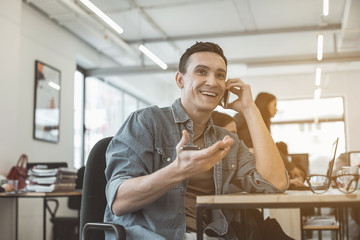Poster - Portrait of beaming male speaking by phone while gesticulating hand. He having job in office. Glad employer telling during labor concept