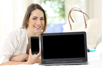 Canvas Print - Hotel guest showing blank smartphone and laptop screens