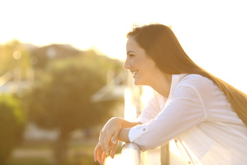 Wall Mural - Profile of a happy woman looking away in a balcony