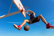 Slam Dunk. Side view of young basketball player making slam dunk