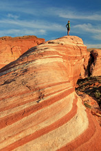 Woman Standing On The The Fire Wave Rock At Sunset, Valley Of Fire State Park, Nevada, USA