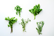 Fresh culinary herbs on white background: rosemary, thyme, mint, basil and parsley in small bunches