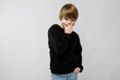 © Ivan Traimak - Portrait of adorable confident little boy standing in studio with hand near his face with hand on pocket on grey background