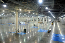 Large Empty Warehouse Interior In An Industrial Building With High Vertical Columns With And High Ceiling And Artificial Lighting Horizontal View