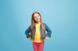 © master1305 - The happy teen girl standing and smiling against pink background.